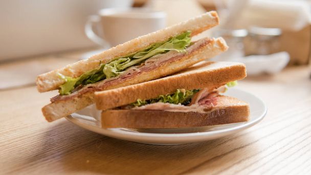  cooked sandwich with salami and lettuce leaves. Fast snack for an office worker - Photo, Image