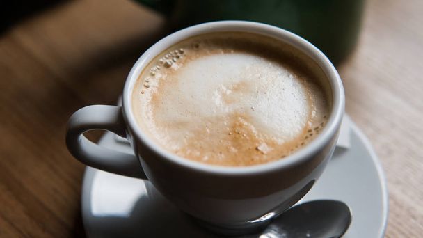 xícara com café em pé no fundo de uma mesa de madeira close-up
 - Foto, Imagem