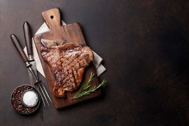 Grilled T-bone steak on stone table. Top view with copy space - Photo, Image