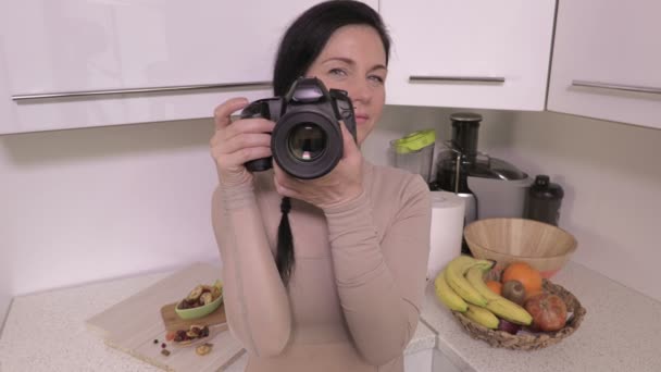 Frau mit professioneller Kamera fotografiert in Küche - Filmmaterial, Video