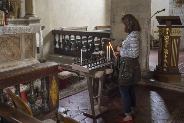 Γυναίκα ανάφλεξη κεριά στην εκκλησία, Chianti, Τοσκάνη, Ιταλία - Φωτογραφία, εικόνα