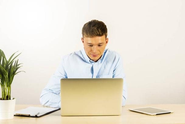 Portrait d'un beau jeune homme souriant utilisant un ordinateur portable b
 - Photo, image