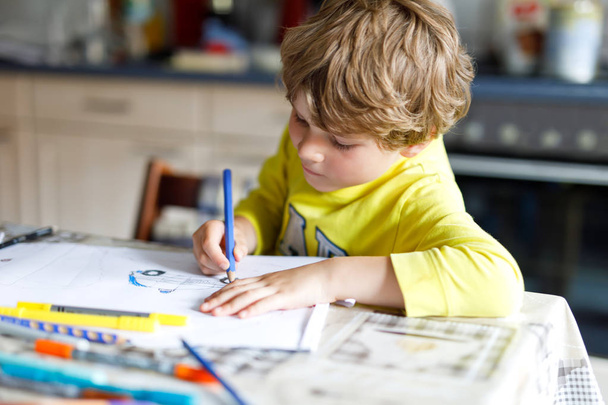 Müder Junge zu Hause macht Hausaufgaben und schreibt Briefe mit bunten Kugelschreibern - Foto, Bild