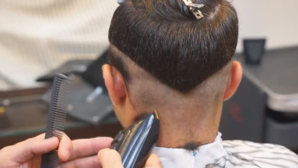 Nahaufnahme von Männern Haarschnitt mit Clipper im Friseursalon. Männer Friseure. Friseur schneidet den Kundenautomaten für Haarschnitte. - Filmmaterial, Video