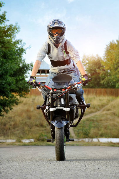 Frontview of young strong biker sitting on sport motorcycle. - Fotó, kép