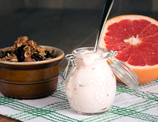Jar with homemade yogurt. Granola from several types of cereals  - Photo, Image