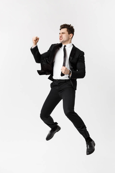 Comprimento total Retrato Engraçado alegre empresário pulando no ar sobre fundo cinza
 - Foto, Imagem