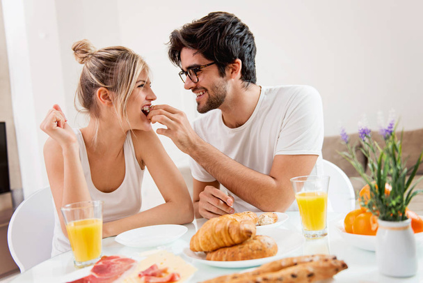 Cute young couple enjoying their breakfast together - Foto, afbeelding