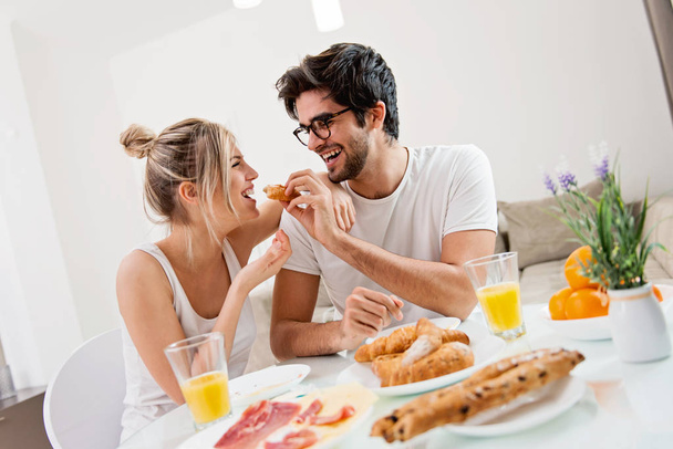 Cute young couple enjoying their breakfast together - Foto, imagen
