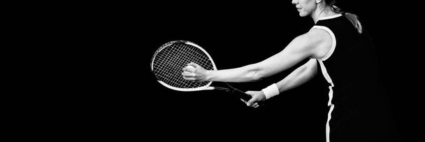 Athlete playing tennis with a racket  against black background - Фото, изображение