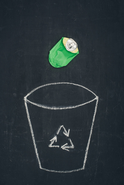 metal can falling into drawn trash bin with recycle sign on chalkboard - Photo, Image