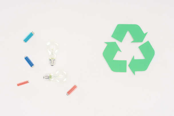 vista superior de bombillas y baterías con letrero de reciclaje en blanco
 - Foto, Imagen