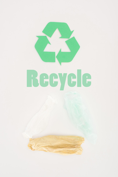 top view of plastic bags with recycle sign on white - 写真・画像