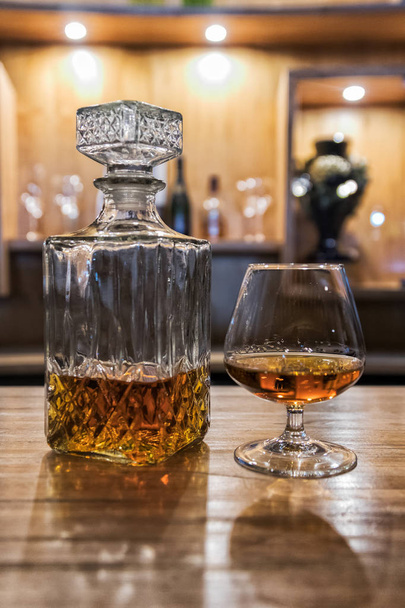 Starožitný whisky láhev balónek ve tvaru skla na barový pult. - Fotografie, Obrázek