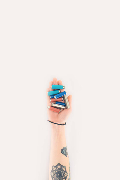 recortado tiro de mujer sosteniendo baterías en mano aislado en blanco
 - Foto, Imagen