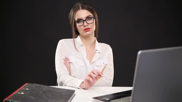 όμορφη σέξι κορίτσι στο επιχειρηματικό στυλ ποζάρει στο γραφείο με φορητό υπολογιστή - Πλάνα, βίντεο