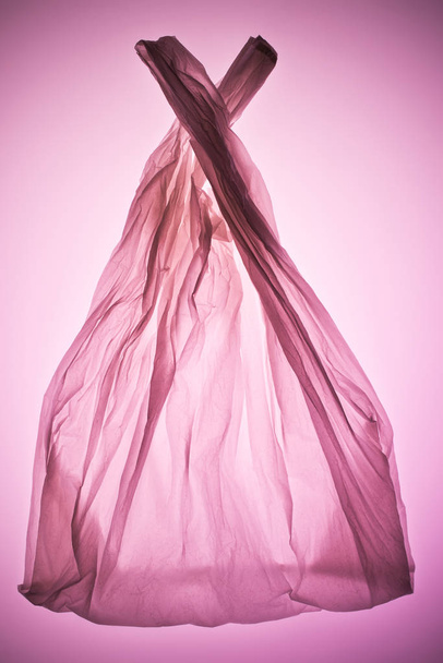 мятый прозрачный пластиковый пакет под розовым тонированным светом
 - Фото, изображение