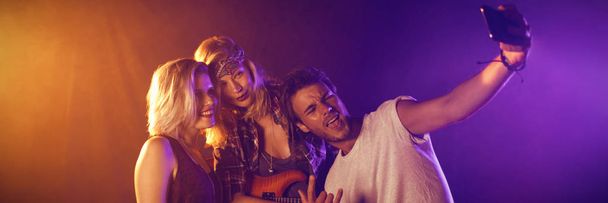 Fan taking selfie with female performers at nightclub - Fotografie, Obrázek