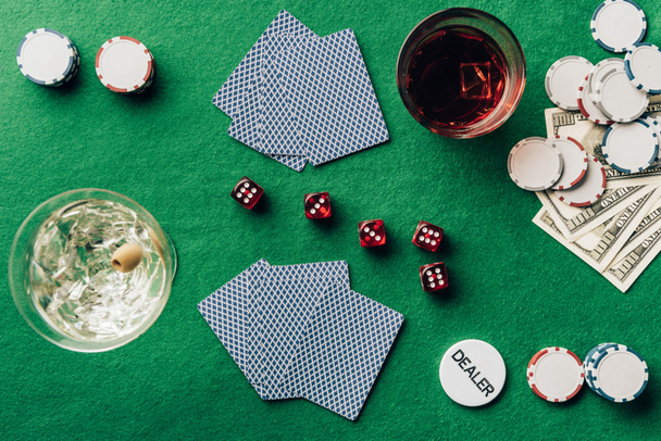 Gambling concept with alcohol on casino table with cards and dice - Fotó, kép