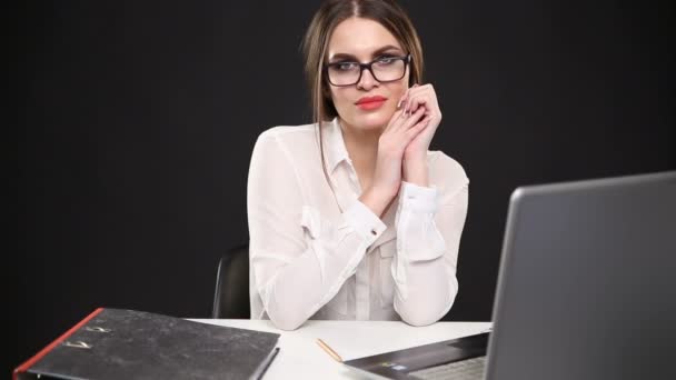 όμορφη σέξι κορίτσι στο επιχειρηματικό στυλ ποζάρει στο γραφείο με φορητό υπολογιστή - Πλάνα, βίντεο