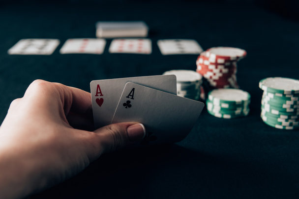 Femme tenant des cartes à jouer par table de casino
 - Photo, image