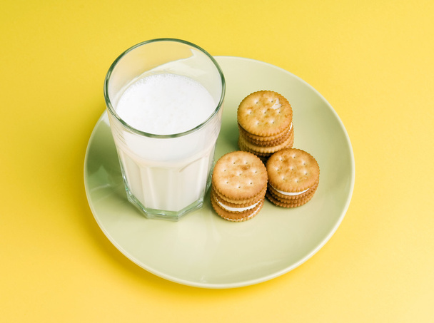 Plate of milk cream filled shortcake and a glass of milk isolated on plate - Valokuva, kuva