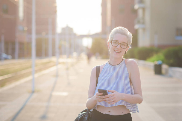 junge Frau im Freien hält Smartphone in die Kamera - Foto, Bild