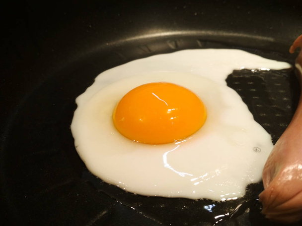 Τηγανιτό αυγό σε ένα τηγάνι με λουκάνικο. Closeup των τηγανητά αυγά. - Φωτογραφία, εικόνα