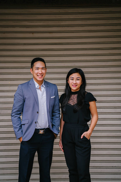 portrait of two professional business people on a street in a city in Asia. The man and woman are both professionally dressed. - Foto, Imagem