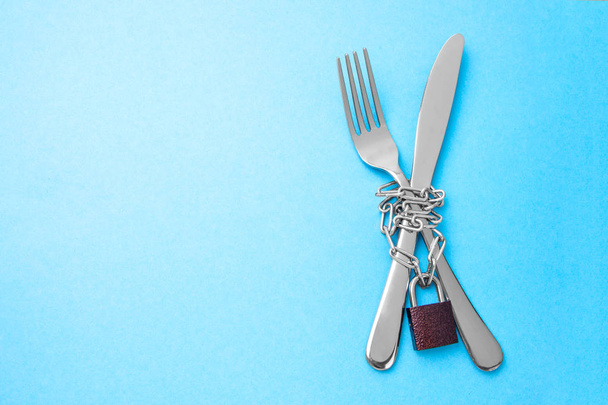 Nälkä lakko ruokavalio laihtuminen. Haarukka ja veitsi on kääritty
 - Valokuva, kuva