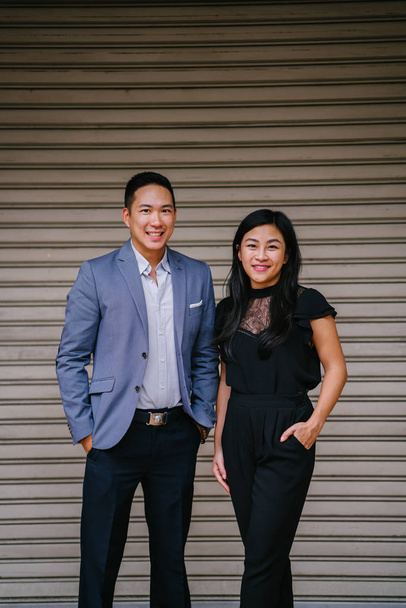portrait of two professional business people on a street in a city in Asia. The man and woman are both professionally dressed. - Photo, Image