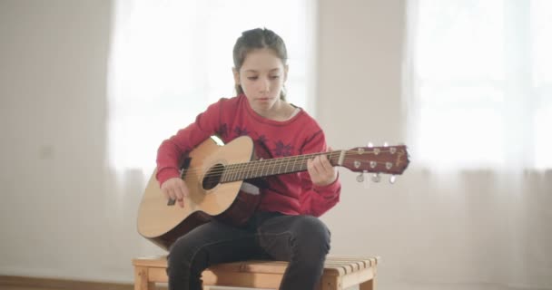 Nuori tyttö soittaa kitaraa ja laulaa
 - Materiaali, video