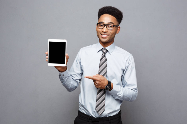 Business Concept - Happy handsome professional african american businessman showing digital tablet to client. - Photo, Image