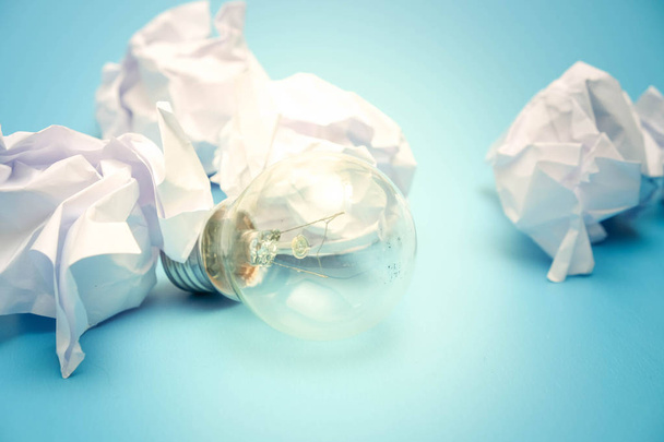 great concept with crumpled office paper and light bulb on a blue background - Foto, Bild