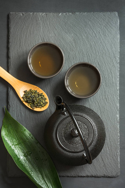 Green japanese tea on black slate background. Top view with copy space. - Foto, afbeelding