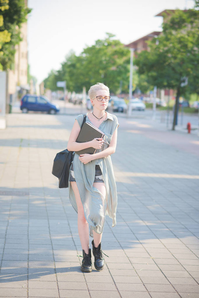 mujer joven sosteniendo libros caminando por la ciudad
  - Foto, imagen