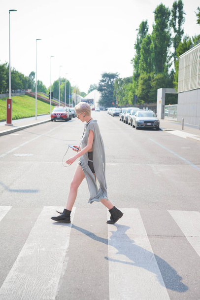 fiatal nő séta, zenehallgatás, smartphone  - Fotó, kép