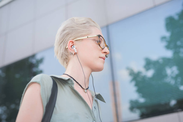 молодая женщина слушает музыку в наушниках
  - Фото, изображение