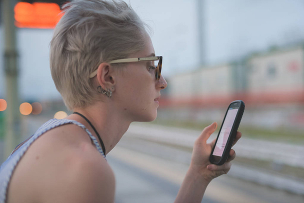 Nuori nainen käyttää älypuhelinta kaupungissa  - Valokuva, kuva