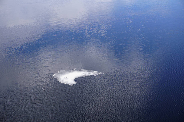 Маленький лед, изолированный на поверхности воды
. - Фото, изображение