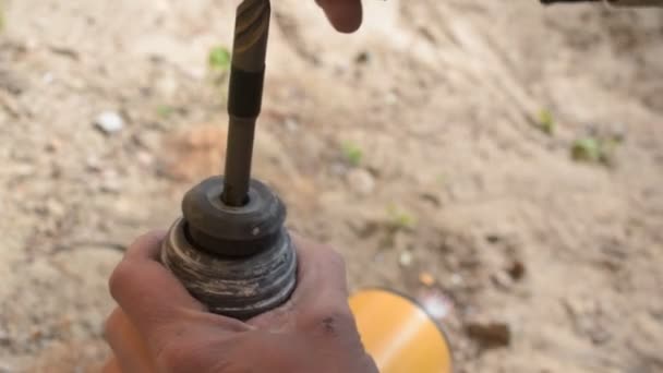 Kezében egy munkavállaló egy fúró beszúrásával kültéri vezeték nélküli kalapács - Felvétel, videó