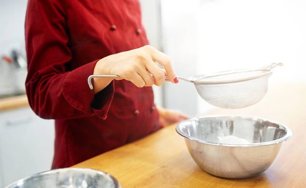 chef with flour in bowl making batter or dough - 写真・画像
