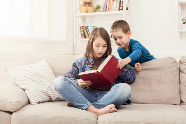Jeune fille lecture livre pour son frère
 - Photo, image