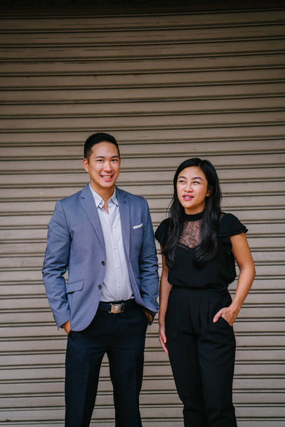 portrait of two professional business people on a street in a city in Asia. The man and woman are both professionally dressed. - Foto, Imagen