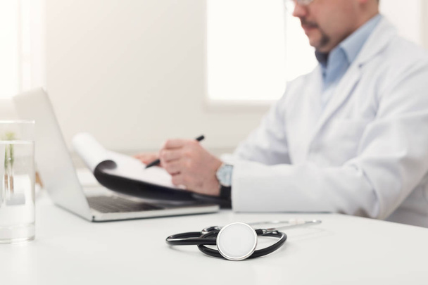 Лікар пише нотатки в офісі, крупним планом
 - Фото, зображення
