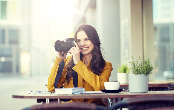 happy tourist woman with camera at city cafe - Valokuva, kuva
