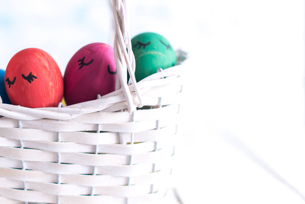 Easter eggs in a white basket on a wooden background - Φωτογραφία, εικόνα