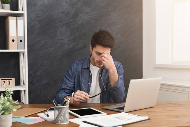Κουρασμένος επιχειρηματίας με το laptop στο μοντέρνο λευκό - Φωτογραφία, εικόνα