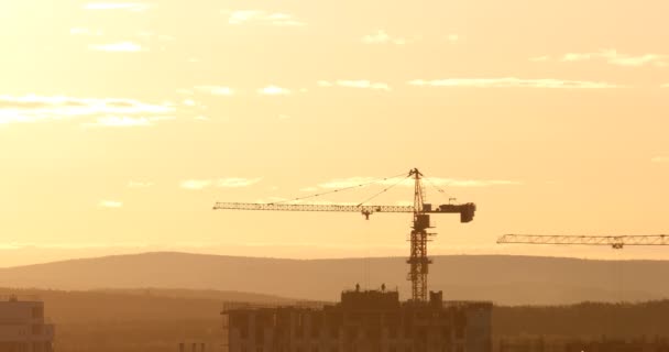 guindaste torre no local de construção contra o céu pôr do sol. Ekaterinburg, Rússia. Vídeo. UltraHD (4K
) - Filmagem, Vídeo