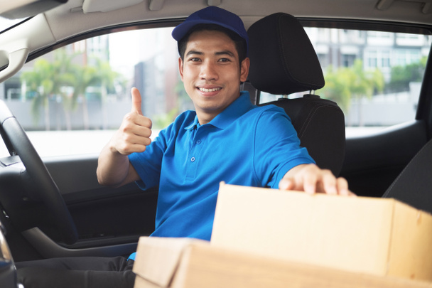 Delivery driver driving car with packages  - Photo, Image